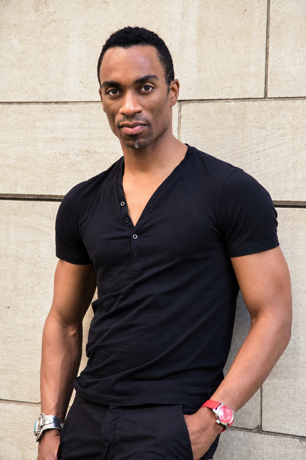 Desmond Richardson in a black shirt standing against a stone wall