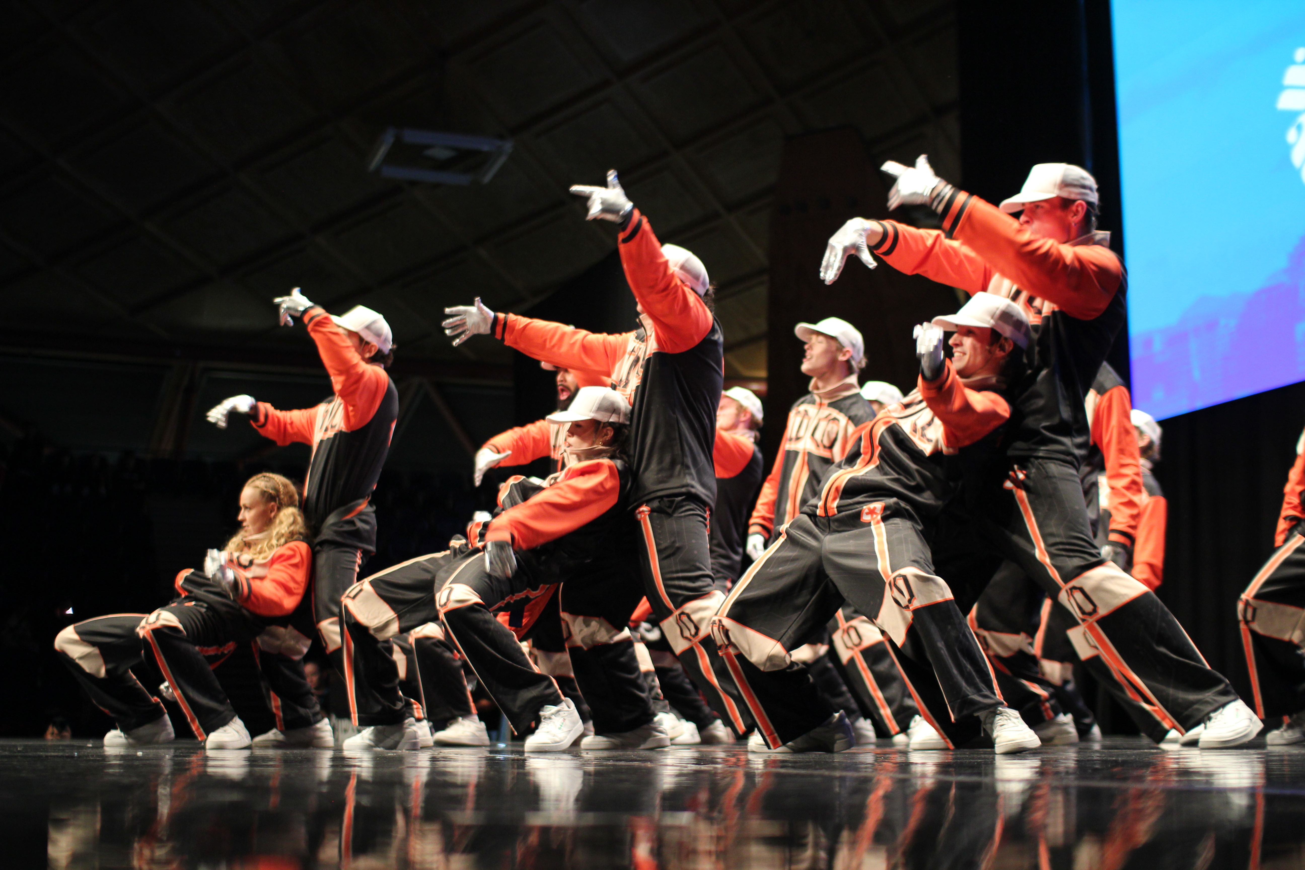 Identity Dance Company (IDCO) in black and orange performing in formation at World Dance Crew Championship 2025