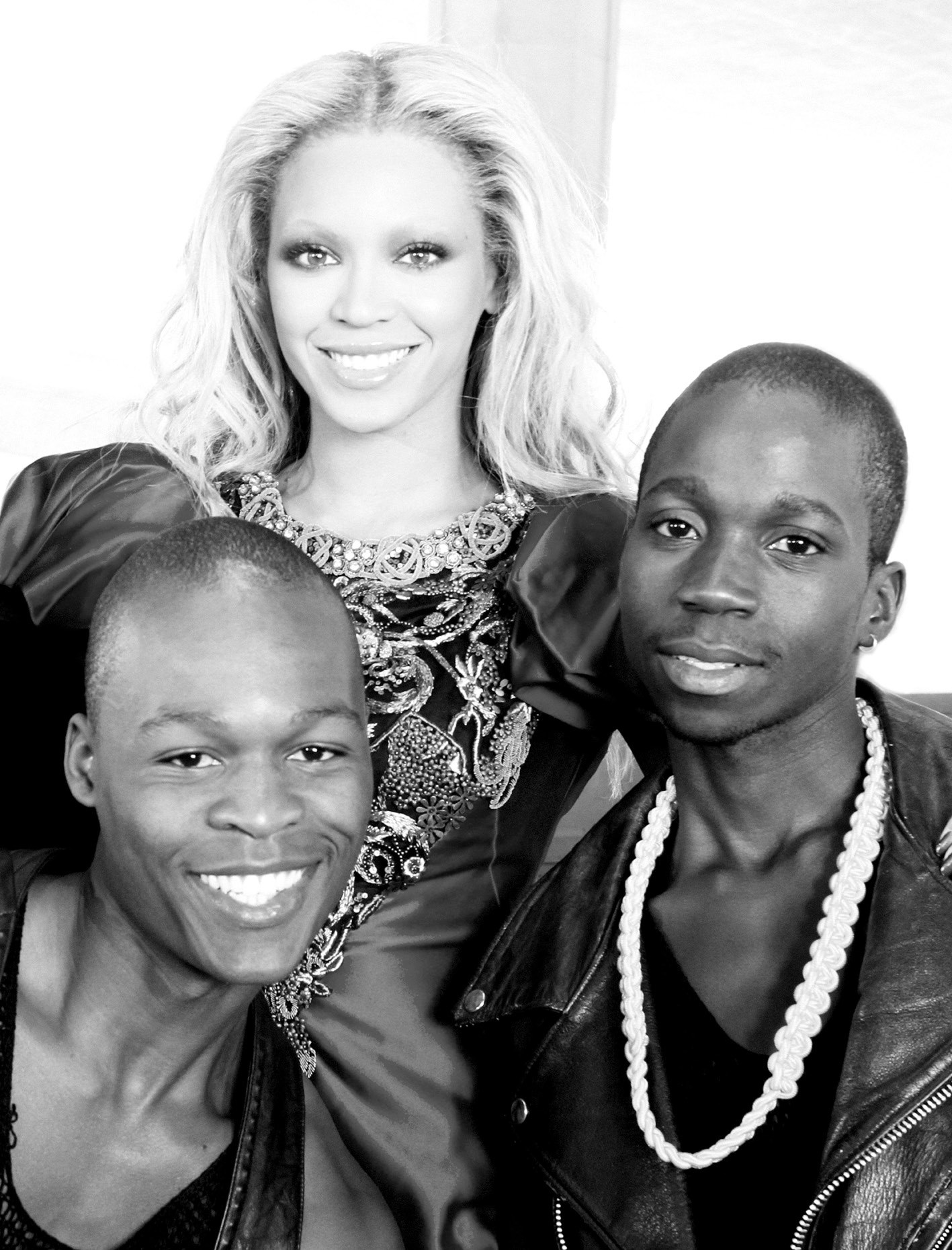 WTOFO dancers Mario Buce and Xavier Campione seated in yellow and pink coats under a Maputo overpass